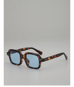 Close-up of tortoise shell square sunglasses with blue lenses and silver rivets