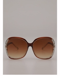 Close-up of oversized sunglasses with brown gradient lenses and silver metal hinge details