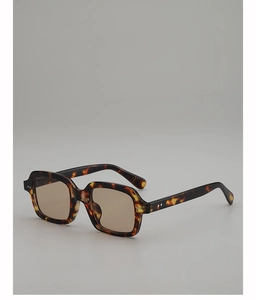 Macro detail of leopard print sunglasses frame with metal rivets and tinted lenses