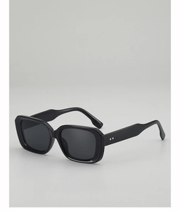 Détail de lunettes de soleil carrées noires avec rivets en losange argentés sur les branches