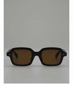 Close-up of sleek black square sunglasses with brown lenses and metal dot details