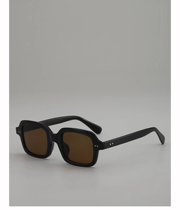 Detail of retro black square sunglasses featuring brown lenses and silver dot studs