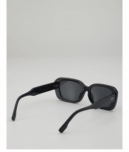 Gros plan sur des lunettes de soleil carrées noires avec rivets argentés sur la monture