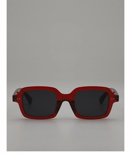 Detail shot of red translucent square frame sunglasses with black lenses and metal rivets