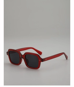 Detail of translucent red square frame sunglasses with integrated nose pads and grey lens