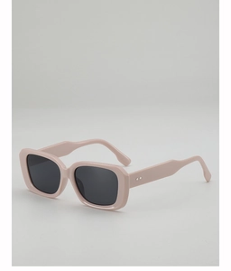 Détail de lunettes de soleil rectangulaires roses avec rivets argentés et verres foncés