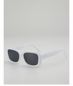 Détail de lunettes de soleil carrées blanches avec rivets argentés en forme de losange