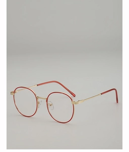 Detail of red and gold metal round glasses frame with slim temples and silicone nose pads