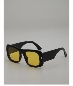 Close-up of square black sunglasses with yellow lenses and silver rivet details