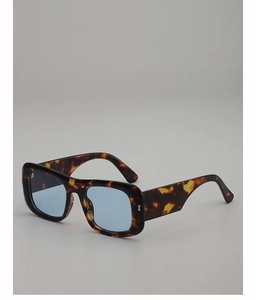 Detail of square tortoiseshell frame sunglasses with light blue translucent lenses