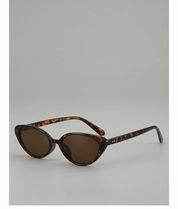 Dettaglio di occhiali da sole cat-eye retrò con montatura tartarugata marrone e rivetti