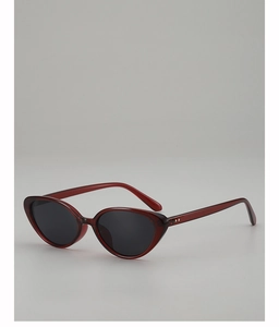 Dettaglio degli occhiali da sole cat-eye bordeaux con lenti scure e rivetti in metallo