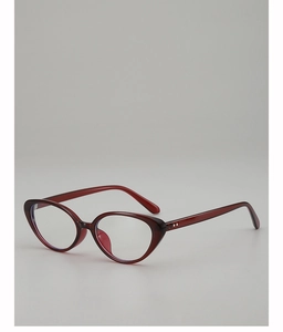 Dettaglio della montatura cat-eye bordeaux con rivetti argentati su sfondo grigio