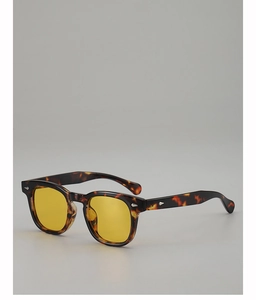 Detail of tortoise shell frame sunglasses with yellow lenses and silver rivets