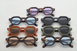 Flat lay of hexagonal sunglasses in various colors including tortoiseshell and olive green