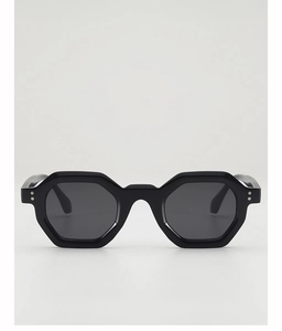 Close-up of hexagonal thick-frame sunglasses featuring silver studs and dark polarized lenses