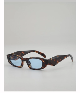 Macro detail of tortoiseshell geometric frame and light blue lens of cat eye sunglasses