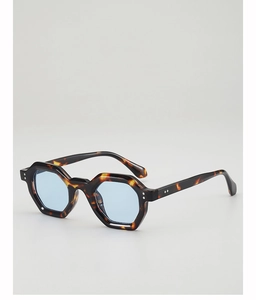 Close-up of tortoise shell polygonal sunglasses with light blue lenses and metal rivets