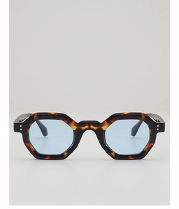 Detail of tortoise shell hexagonal sunglasses with light blue lenses and silver rivets