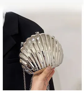 Dettaglio della borsa a conchiglia argento metallizzato con texture lucida e catena