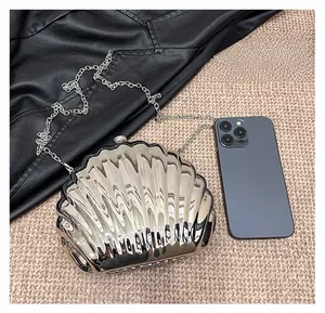 Dettaglio borsa da sera a conchiglia argento con finitura metallica e catena