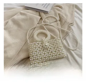 Detail of handmade white pearl crossbody bag featuring woven texture and round handle