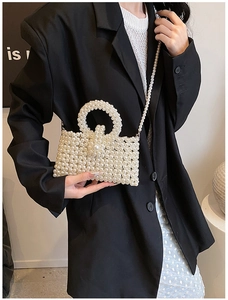 Detail of a handmade white pearl beaded mini bag with cross-body chain and large pearl clasp