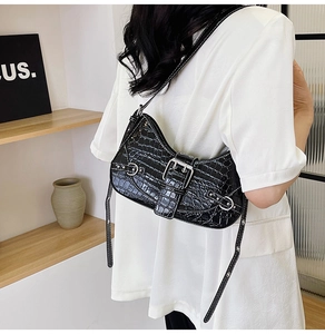 Gros plan du sac bandoulière noir effet crocodile avec détails argentés sur modèle
