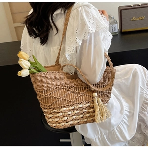 Détail du sac à bandoulière en paille tisse main avec pompons en perles de bois