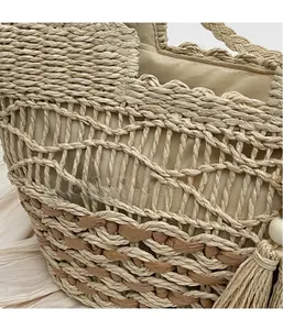 Détail d'un sac à main en paille tissée creuse avec glands et doublure en tissu