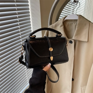 Minimalist black square crossbody bag with contrast stitching and golden clasp buckle