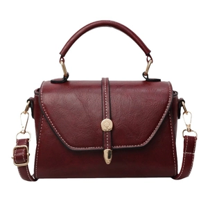 Vintage burgundy square handbag with top handle and contrast stitching on white background
