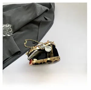 Detail showing the inner capacity of a leopard print clutch bag with gold chain strap