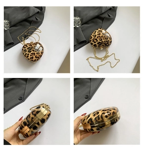 Detail view of heart-shaped leopard print clutch with gold handle and chain strap