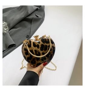 Close-up of leopard print heart-shaped bag with gold chain and crystal clasp detail