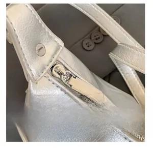 Close-up of smooth metal zipper and silver wrinkled leather texture on the handbag