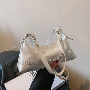 Detail of white patent leather handbag with silver chain and rivet studs decoration