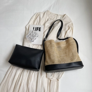 Straw and black leather bucket bag set with matching pouch on white dress background