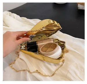 Details der goldenen Muschel-Abendtasche mit Platz für Kosmetik und feiner Kette
