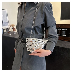 Detailaufnahme der silbernen muschelförmigen Metalltasche mit radialer Streifenstruktur