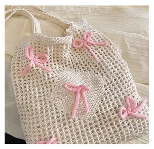 Close-up of woven mesh tote bag featuring decorative pink knit bows and texture