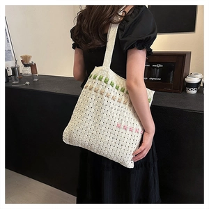 Detailed texture of hand-woven off-white crochet tote bag with colorful accent straps