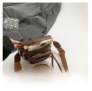 Detail showing spacious multi-layer compartments of brown woven crossbody bag with phone and wallet