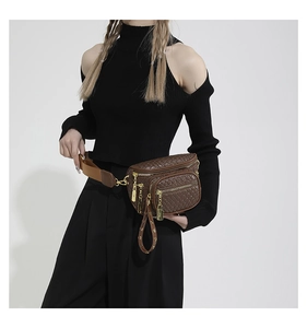 Detailed view of dark brown woven texture waist bag with golden zippers and nylon strap