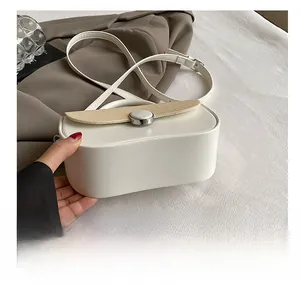 Detailed view of the wear-resistant bottom and smooth beige leather of the crossbody bag