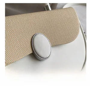 Close-up of contrast textures featuring khaki woven flap and white leather bag body