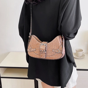 Brown crocodile pattern crossbody bag with vintage silver buckle shown on shoulder