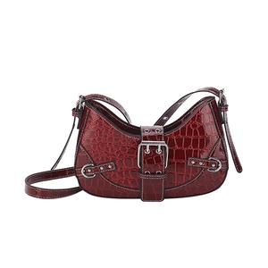 Deep red crocodile embossed crescent shoulder bag with silver buckle on white background