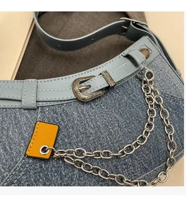 Details der Jeans-Umhängetasche mit Vintage-Silberbeschlägen und mehrlagigen Ketten