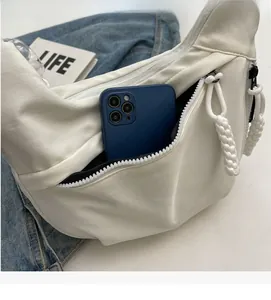 Détail de la poche avant du sac croissant blanc montrant l'espace pour un smartphone